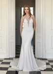 alt='Această rochie de mireasă tip sirenă din crep, cu decolteu în V, este o odă adusă rafinamentului. Designul său curat și elegant pune subtil silueta în valoare, în timp ce mărgelele adaugă o strălucire rafinată.'